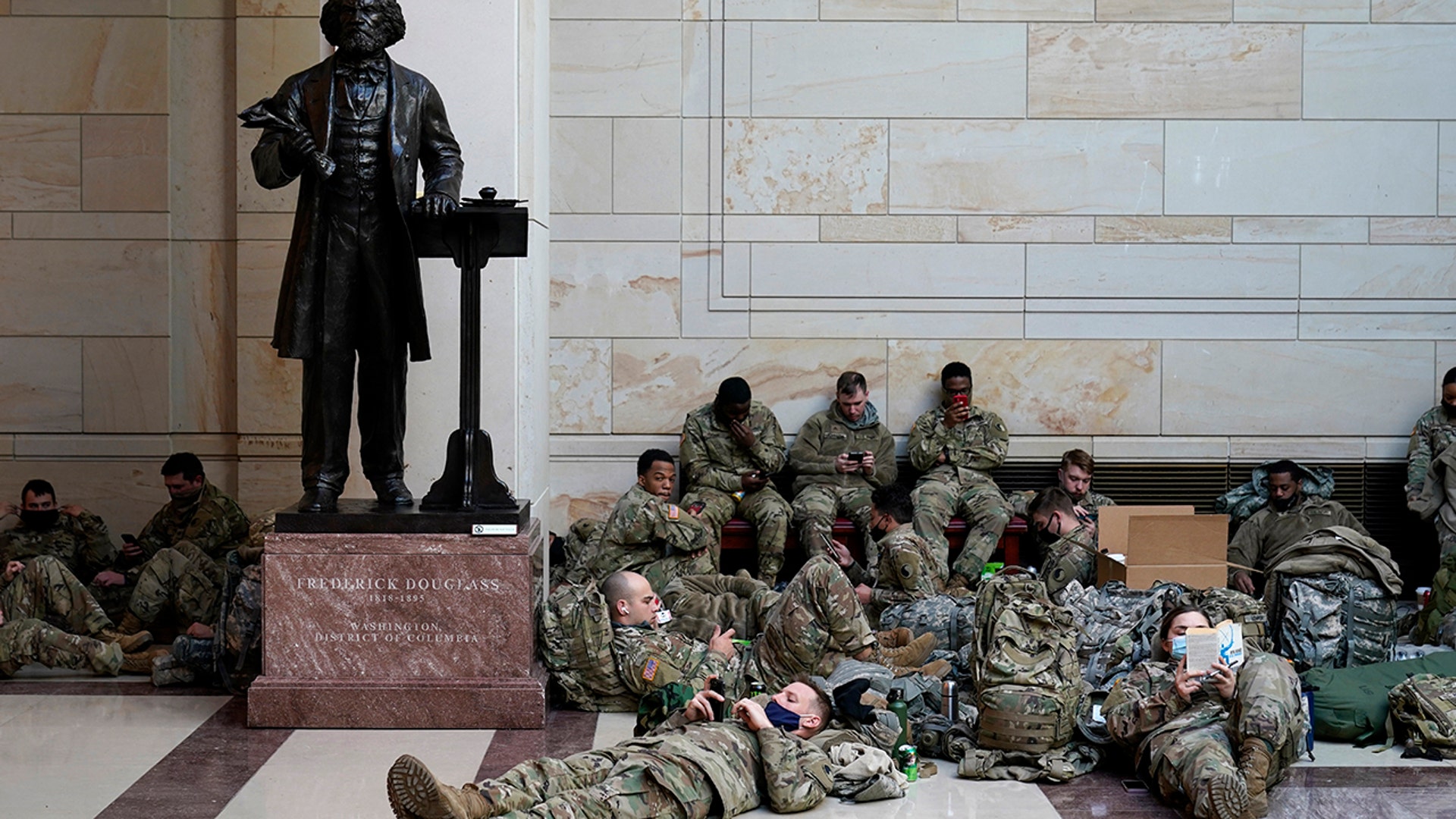 Troops hold inside the Capitol Visitor's Center to reinforce security at the Capitol in Washington, Wednesday, Jan. 13, 2021. The House of Representatives is pursuing an article of impeachment against President Donald Trump for his role in inciting an angry mob to storm the Capitol last week.. (AP Photo/Alex Brandon)