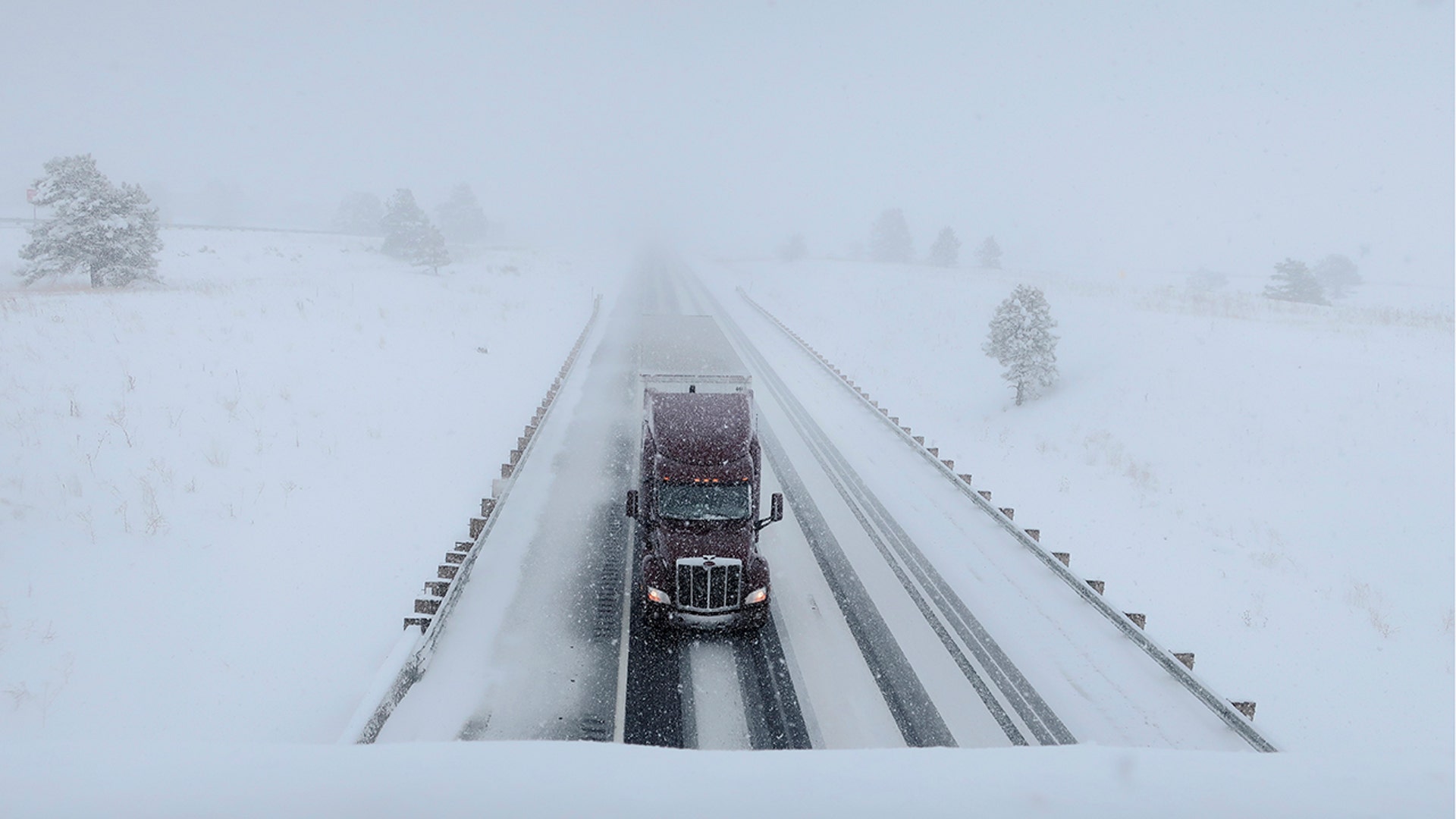 A semi-truck travels on Interstate 40 in Bellemont, Ariz., Monday, Jan. 25, 2021. A series of winter storms have dropped more precipitation in Flagstaff than the city had during last summer's monsoon season. The recent snow measured as water topped the amount of rain that fell from mid-June through September, the driest monsoon season on record. (AP Photo/Felicia Fonseca)