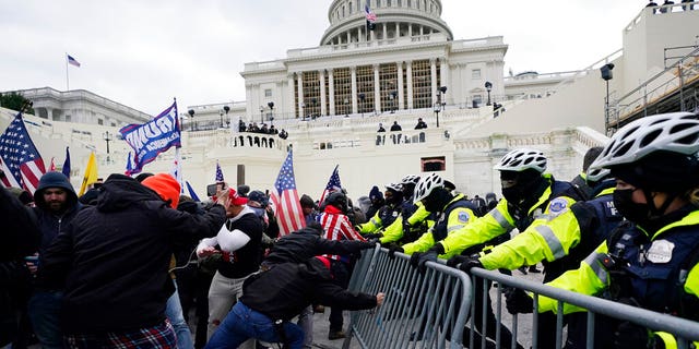 特朗普的支持者试图突破警察的障碍，2021年1月6日星期三，在华盛顿国会大厦。（美联社照片/Julio Cortez）