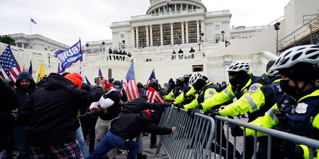 Trump supporters try to break through a police barrier, Wednesday, Jan. 6, 2021, at the Capitol in Washington. (AP Photo/Julio Cortez)