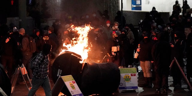 A trash can burns as people take part in a protest against police brutality, late Sunday, Jan. 24, 2021, in downtown Tacoma, Wash. (Associated Press)
