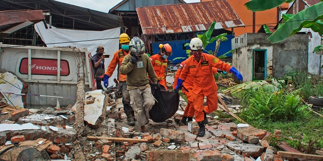 Rescuers carry a body bag containing a victim of an earthquake in Mamuju, West Sulawesi, Indonesia, Friday, Jan. 15, 2021. Ready.gov advises creating an emergency supply kit and family communication plan in case of an earthquake.
