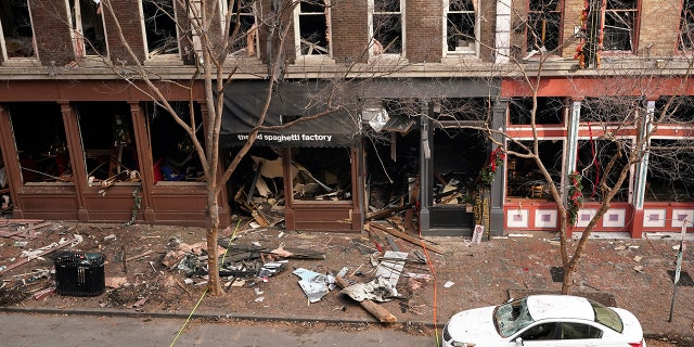 In this Dec. 29, 2020 file photo, debris remains on the sidewalk in front of buildings damaged in a Christmas Day explosion in Nashville, Tenn. (AP Photo/Mark Humphrey, File)