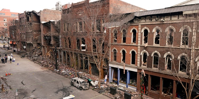 In this Tuesday, Dec. 29, 2020 file photo, debris remains on the sidewalks in front of buildings damaged in a Christmas Day explosion in Nashville, Tenn.  (AP Photo/Mark Humphrey)