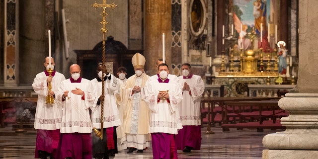 Cardinal Pietro Parolin, center, arrives in procession to celebrate a new year Mass in St. Peter's Basilica at the Vatican, Friday, Jan. 1, 2021. (AP Photo/Alessandra Tarantino, pool)
