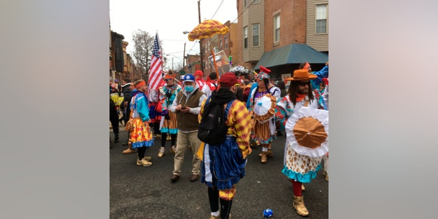 Costumed participants take to the streets of their south Philadelphia to celebrate the New Year of the Mummer tradition despite the annual event being officially canceled and large gatherings banned due to the coronavirus pandemic, Friday, January 1 2021 in Philadelphia.  (AP Photo / Ron Todt)