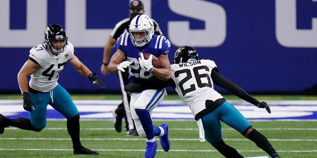 Indianapolis Colts' Jonathan Taylor (28) runs past Jacksonville Jaguars' Jarrod Wilson (26) during the first half of an NFL football game, Sunday, Jan. 3, 2021, in Indianapolis. (AP Photo/AJ Mast)