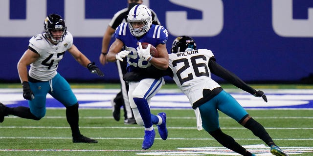 Indianapolis Colts' Jonathan Taylor (28) runs past Jacksonville Jaguars' Jarrod Wilson (26) during the first half of an NFL football game, Sunday, Jan. 3, 2021, in Indianapolis. (AP Photo/AJ Mast)