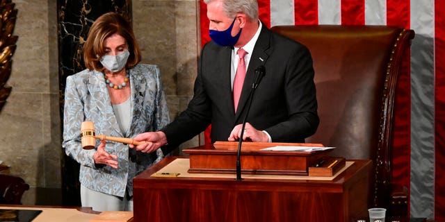 Speaker of the House Nancy Pelosi is handed the Speaker's gavel by House Minority Leader Kevin McCarthy, R-Calif., on the opening day of the 117th Congress on Capitol Hill in Washington, Sunday, Jan. 3, 2021. (Erin Scott/Pool via AP)