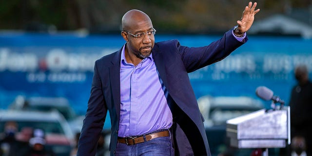Democratic U.S. Senate candidate Rev. Raphael Warnock waves to supporters during a drive-in rally, Sunday, Jan. 3, 2021, in Savannah, Ga. 