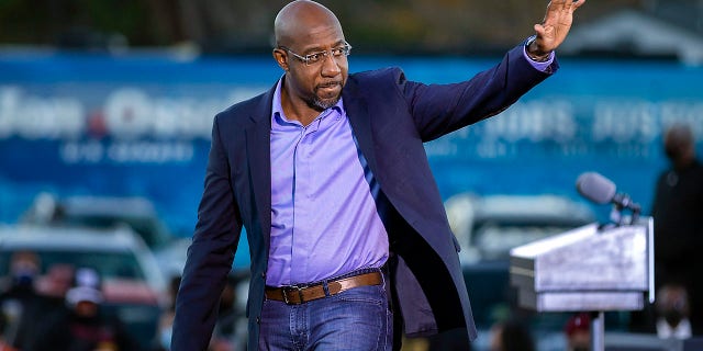 Rev. Raphael Warnock waves to supporters during a drive-in rally, Sunday, Jan. 3, 2021, in Savannah, Georgia.