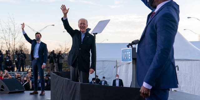 Joe Biden, then president-elect at the time, stands on stage with Georgia Democratic Senate candidates Raphael Warnock, right, and Jon Ossoff, left, in Atlanta on Monday, January 4, 2021 (AP Photo / Carolyn Kaster)