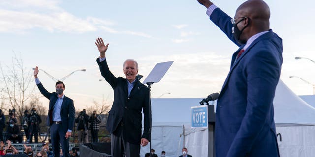 President Biden stands on stage with Georgia Democratic candidates for U.S. Senate Raphael Warnock, reg, and Jon Ossoff, links, in Atlanta, Maandag, Jan.. 4, 2021. Biden and Warnock are two of the targets of a new billboard campaign over their opposition to Georgia's new voting law. (AP Photo / Carolyn Kaster)