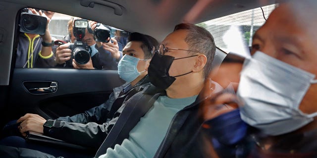 Former law professor Benny Tai, center, a key figure in Hong Kong's 2014 Occupy Central protests and also was one of the main organizers of the primaries, sits in a car after being arrested by police in Hong Kong, Wednesday, Jan. 6, 2021. (Associated Press)