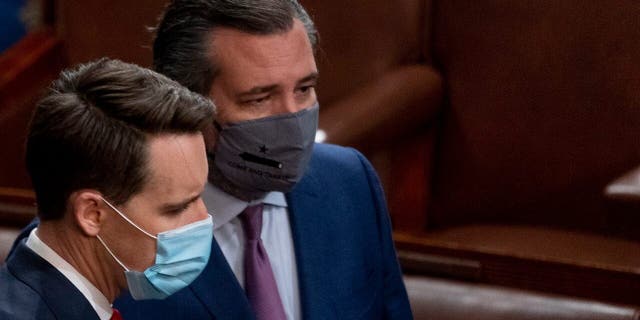 Sen. Josh Hawley, R-Mo., left, and Sen. Ted Cruz, R-Texas, right, speak after Republicans objected to certifying the Electoral College votes from Arizona, during a joint session of the House and Senate to confirm the electoral votes cast in November's election, at the Capitol, Wednesday, Jan 6, 2021. (AP Photo/Andrew Harnik)