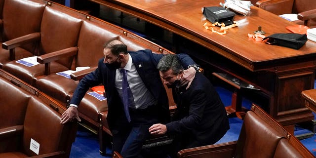 Lawmakers evacuate the floor as protesters try to break into the House Chamber at the U.S. Capitol on Wednesday, Jan. 6, 2021, in Washington. (AP Photo/J. Scott Applewhite)