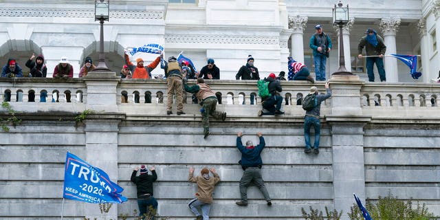 Supporters of President Donald Trump climb the west wall of the the U.S. Capitol on Jan. 6, in Washington. (AP Photo/Jose Luis Magana)