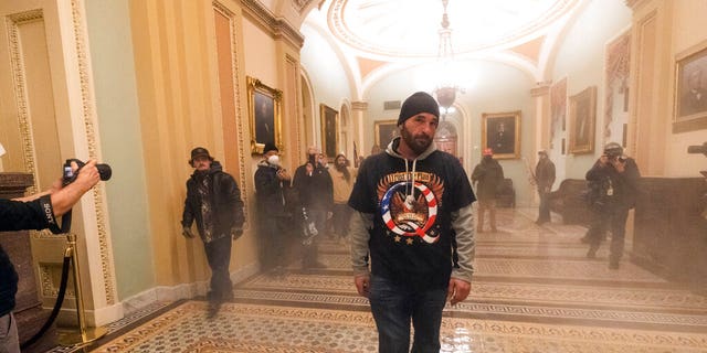 Smoke fills the walkway outside the Senate Chamber as supporters of President Donald Trump are confronted by U.S. Capitol Police officers inside the Capitol,  Jan. 6, in Washington. (AP Photo/Manuel Balce Ceneta)