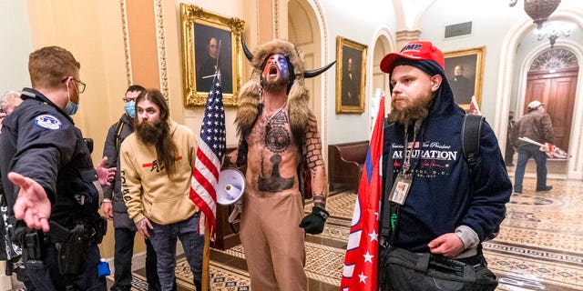 Supporters of President Donald Trump are confronted by Capitol Police officers outside the Senate Chamber inside the Capitol, Wednesday, Jan. 6, 2021 in Washington. (AP Photo/Manuel Balce Ceneta)