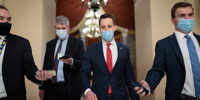 After violent protesters loyal to President Donald Trump storm the U.S. Capitol on Wednesday, Jan. 6, Sen. Josh Hawley, R-Mo., walks to the House chamber to challenge the results of the presidential election in Pennsylvania. (AP Photo/J. Scott Applewhite)