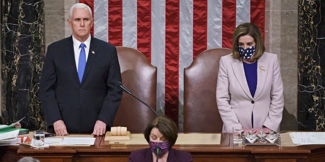 Vice President Mike Pence and Speaker of the House Nancy Pelosi, D-Calif., read the final certification of Electoral College votes cast in November's presidential election during a joint session of Congress after working through the night, at the Capitol in Washington, Thursday, Jan. 7, 2021. (AP Photo/J. Scott Applewhite, Pool)