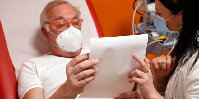 <br /> Dr Alain Guignon reads a prescription before receiving the Pfizer-BioNTech COVID-19 vaccine at a clinic in Strasbourg, eastern France, January 5, 2021 (Associated Press)”/></source></source></picture></div>
<div class=