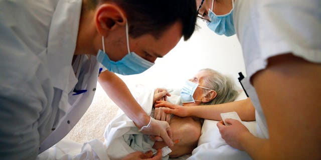 <br>
Dr. Cedric Waechter, left, administers the Pfizer-BioNTech COVID-19 vaccine to a resident of the Bois Fleuris nursing home in Strasbourg in eastern France, Jan. 6, 2021. (Associated Press)