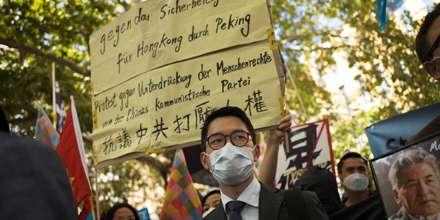 Hong Kong activist Nathan Law, center, takes part in a protest during the visit of Chinese Foreign Minister Wang Yi in Berlin, Germany, on Sept. 1, 2020.  (AP Photo/Markus Schreiber, File)