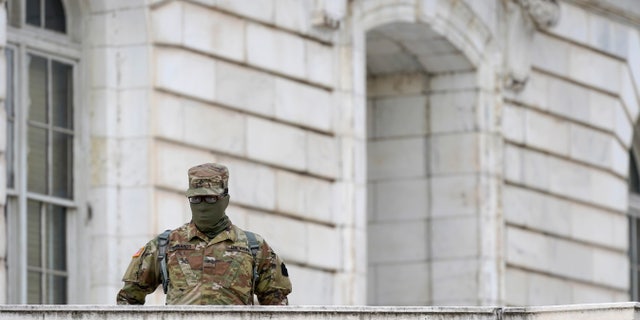 A member of the military stands guard outside Russell Senate Office Building on Capitol Hill in Washington, Friday, Jan. 8, 2021, in response to supporters of President Donald Trump who stormed the U.S. Capitol. 