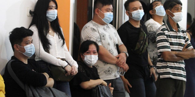 People wait for news of relatives on a Sriwijaya Air passenger jet that lost contact with air traffic controllers after takeoff at Soepadio International Airport in Pontianak, West Kalimantan, Indonesia, Saturday, Jan. 9, 2021. (AP Photo/Helmansyah)