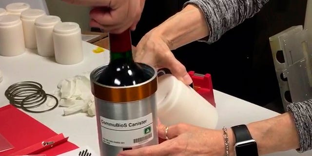 Researchers from Space Cargo Unlimited prepare bottles of French red wine to be flown from Wallops Island, Va., to the International Space Station on Nov. 2, 2019. (Space Cargo Unlimited via AP)