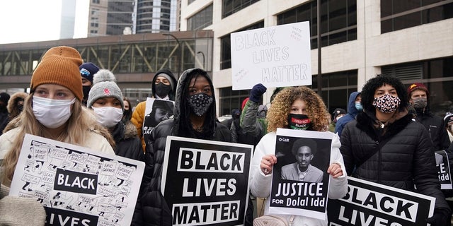 Black Lives Matter protesters, including Markeanna Tyus, center left, and Isis Atallah, center right, stand in the middle of 3rd Avenue South as they prepare to march from the Hennepin County Government Center to demand justice for Jacob Blake. (Anthony Souffle/Star Tribune via AP)