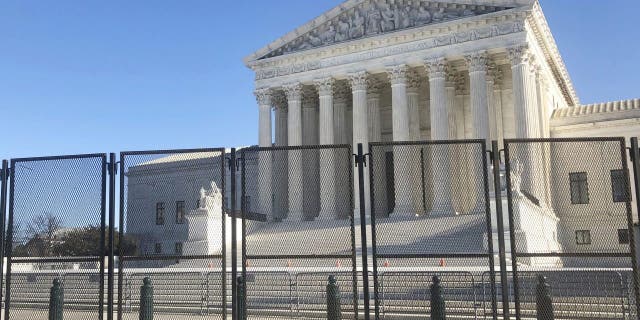 Anti-scaling fencing has been placed in front of the Supreme Court, which stands across the street from the U.S. Capitol, Sunday, Jan. 10, 2021, in Washington. (AP Photo/Alan Fram)