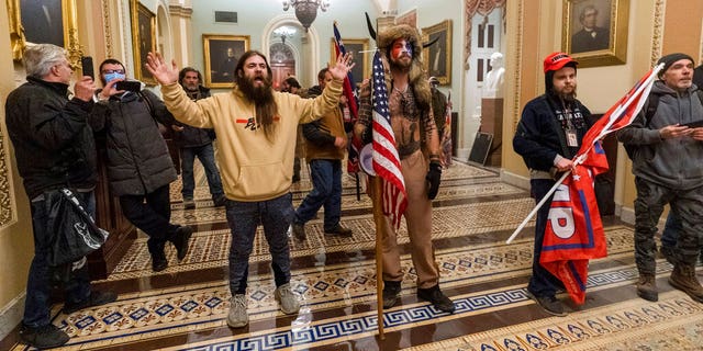Supporters of President Donald Trump are confronted by U.S. Capitol Police officers outside the Senate Chamber inside the Capitol in Washington. 