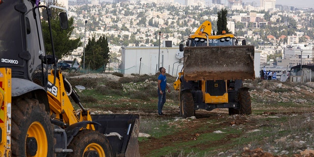 In this Nov. 16, 2020 file photo, workers take a break before European Union officials visit the construction site for Givat Hamatos settlement in Jerusalem. Israel on Monday, Jan. 12, 2021, advanced plans to build 800 new settler homes in the occupied West Bank, a move that could strain ties with the incoming administration of President-elect Joe Biden. Prime Minister Benjamin Netanyahu's office announced the move, saying it would include 100 homes in a settlement where an Israeli woman was killed recently in an alleged terror attack. (AP Photo/Maya Alleruzzo, File)