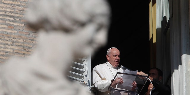 FILE - In this Nov. 8, 2020 file photo, Pope Francis reads his message during the Angelus noon prayer from the window of his studio overlooking St.Peter's Square, at the Vatican. (AP Photo/Alessandra Tarantino, file)