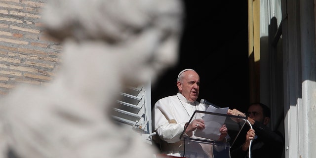 FILE - In this Nov. 8, 2020 file photo, Pope Francis reads his message during the Angelus noon prayer from the window of his studio overlooking St.Peter's Square, at the Vatican. (AP Photo/Alessandra Tarantino, file)