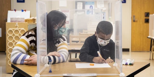 Pre-kindergarten teacher Sarah McCarthy works with a student at Dawes Elementary in Chicago, Monday, Jan. 11, 2021. (Ashlee Rezin Garcia/Chicago Sun-Times via AP, Pool)