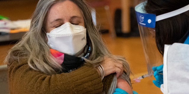 Teacher Lisa Egan is vaccinated with the Moderna coronavirus vaccine at a clinic organized by New York City's Department of Health, Monday, Jan. 11, 2021. (AP Photo/Mark Lennihan)