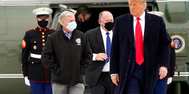 Sen. Lindsey Graham, R-S.C., left, walks with President Donald Trump as they board Air Force One upon arrival at Valley International Airport, Tuesday, Jan. 12, 2021, in Harlingen, Texas, after visiting a section of the border wall with Mexico in Alamo, Texas. (AP Photo/Alex Brandon)