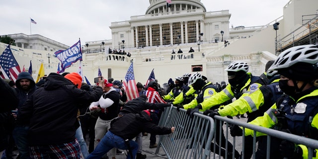 President Trump supporters try to break through a police barrier at the Capitol in Washington, D.C., on Jan. 6, 2021. (AP Photo/Julio Cortez, File)