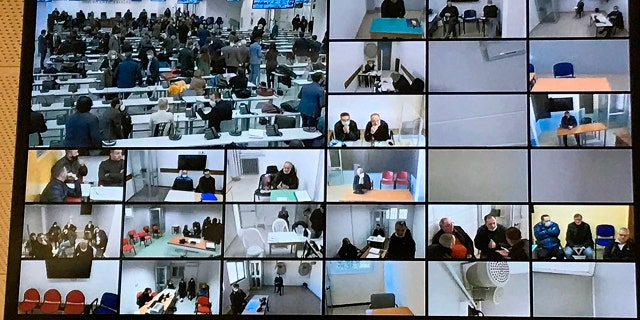 A screen anchored to the ceiling shows the participants following the first hearing of a maxi-trial against more than 300 defendants of the ‘ndrangheta crime syndicate in a specially constructed bunker near the Calabrian town of Lamezia Terme, southern Italy, Wednesday, Jan. 13, 2021. (AP Photo/Gianfranco Stara)