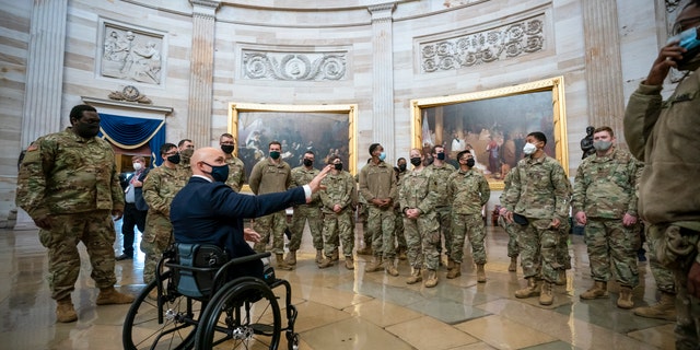 Rep. Brian Mast, R-Fla., left, visits with National Guard troops who are helping with security at the Capitol Rotunda in Washington, Wednesday, Jan. 13, 2021. (AP Photo/J. Scott Applewhite)