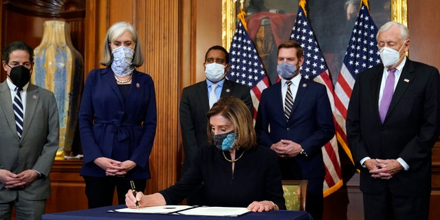 House of Commons Speaker Nancy Pelosi of California signs the article of impeachment against President Donald Trump during a rally ceremony before passing it to the Senate for trial on Capitol Hill, Washington, on Wednesday, January 13, 2021 (Credit: AP Photo / Alex Brandon)