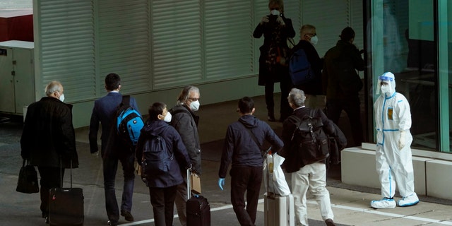 Members of the World Health Organization team arrive at the airport in Wuhan in central China's Hubei province on Thursday, Jan. 14, 2021. A global team of researchers arrived Thursday in the Chinese city where the coronavirus pandemic was first detected to conduct a politically sensitive investigation into its origins amid uncertainty about whether Beijing might try to prevent embarrassing discoveries. (AP Photo/Ng Han Guan)