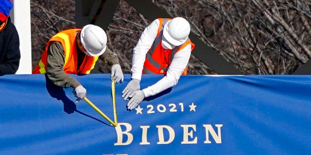 Workers put up bunting on a press riser for the upcoming inauguration of President-elect Joe Biden and Vice President-elect Kamala Harris, on Pennsylvania Ave. in front of the White House, Thursday, Jan. 14, 2021, in Washington. (AP Photo/Gerald Herbert)