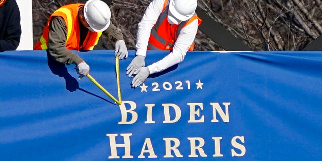 Workers put up bunting on a press riser for the upcoming inauguration of President-elect Joe Biden and Vice President-elect Kamala Harris, on Pennsylvania Ave. in front of the White House, Thursday, Jan. 14, 2021, in Washington. (AP Photo/Gerald Herbert)