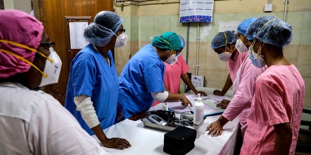 Hospital staff goes through the documents prior to COVID-19 vaccination drive at a hospital in Kolkata, India, Saturday, Jan. 16, 2021. India started inoculating health workers Saturday in what is likely the world's largest COVID-19 vaccination campaign, joining the ranks of wealthier nations where the effort is already well underway. (AP Photo/Bikas Das)