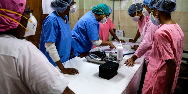 Hospital staff goes through the documents prior to COVID-19 vaccination drive at a hospital in Kolkata, India, Saturday, Jan. 16, 2021. India started inoculating health workers Saturday in what is likely the world's largest COVID-19 vaccination campaign, joining the ranks of wealthier nations where the effort is already well underway. (AP Photo/Bikas Das)