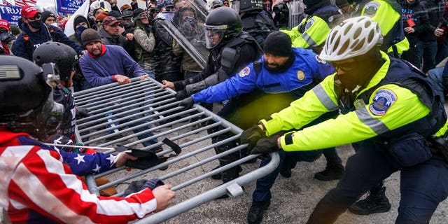 Rioters attempt to cross a police barrier at the Capitol in Washington.  (AP Photo / John Minchillo)